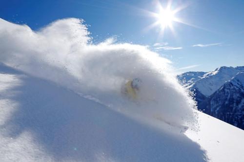 a person is snowboarding down a snow covered slope at Haus Partoll in Kappl