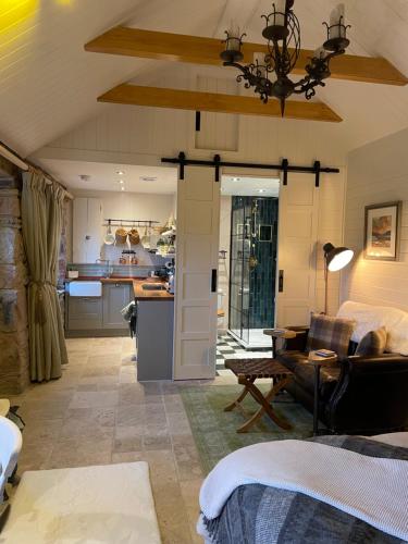 a kitchen and a living room with a couch and a table at Charming stone Bothy at Loch Lomond in Luss
