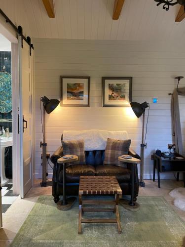a living room with a couch and a table at Charming stone Bothy at Loch Lomond in Luss