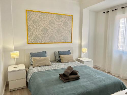 a bedroom with a large bed with two lamps on it at Apartment near the BIO PARC in Valencia