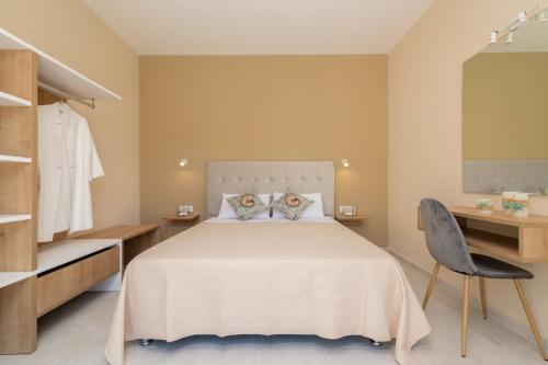 una camera con un grande letto e una sedia di Spartakos Luxury Villa 5 a Plános