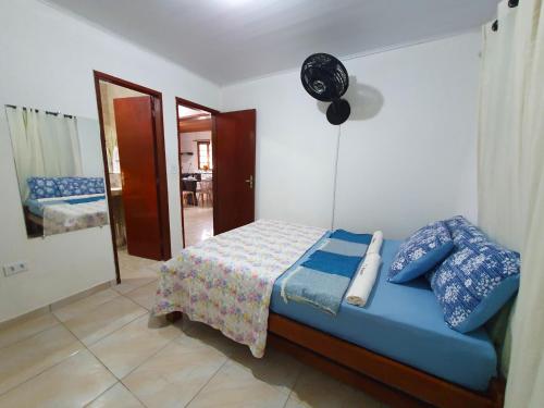 a bedroom with a blue bed and a mirror at Antunes vila maragogi in Maragogi
