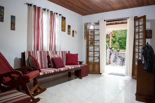 ein Wohnzimmer mit einem Sofa und einer offenen Tür in der Unterkunft Antunes vila maragogi in Maragogi