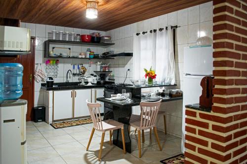 a kitchen with a table and two chairs in it at Antunes vila maragogi in Maragogi