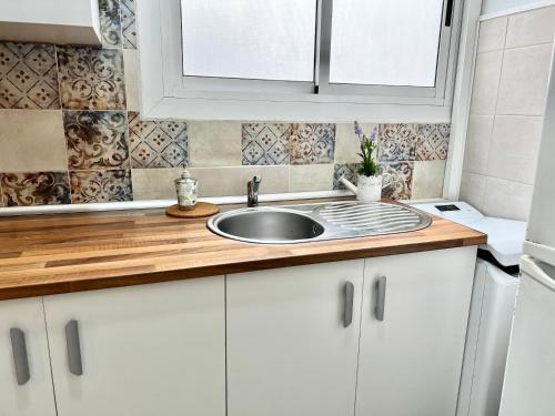 a kitchen with white cabinets and a sink at Apartment near the BIO PARC in Valencia