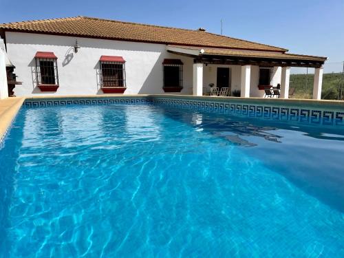a swimming pool in front of a house at Casa Manolín in Córdoba