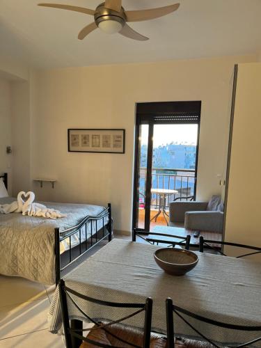 Candia Hotel في مدينة خانيا: غرفة نوم بسرير ومروحة سقف
