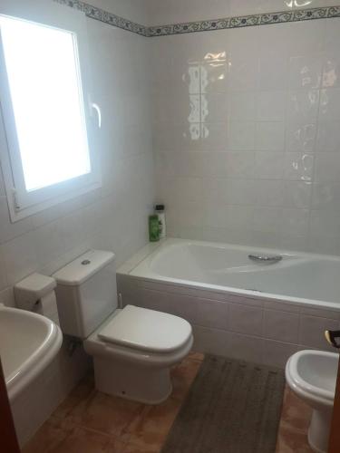 a bathroom with a toilet and a tub and a sink at VISTA SUPERIOR hola ZEEZICHT!! in Cumbre del Sol