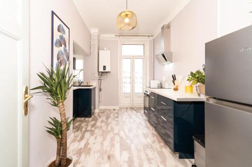 una cocina con una palmera en el medio. en Audace - Magnifique Appartement 75m2 - Position Centrale Gare-Pompidou-Nouvelle Ville - Garage Privé - 2 à 4 Personnes en Metz