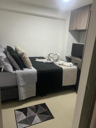 een slaapkamer met een bed en een televisie. bij Acogedor apartamento en Itagui in Itagüí
