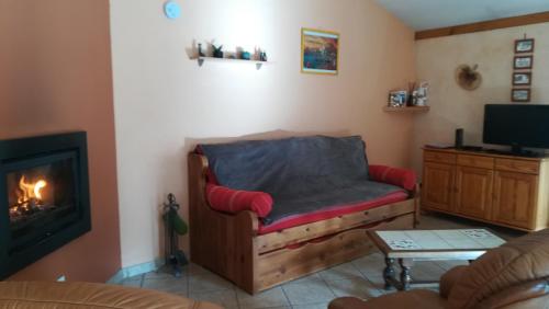 ein Wohnzimmer mit einem Sofa und einem Kamin in der Unterkunft Gîte du Pressoir in Cerdon