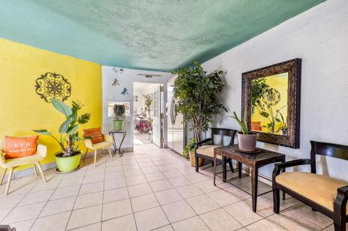 a living room with chairs and tables and plants at Inn at Palm Springs in Palm Springs