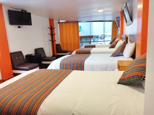 a hotel room with two beds and a flat screen tv at Amakonkay Machupicchu in Machu Picchu