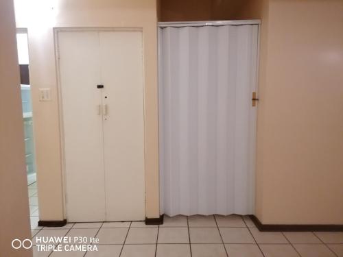 two white doors in a room with a tile floor at Kingsview 201 in Margate