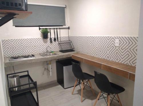 a kitchen with a counter and some chairs in a room at APARTAMENTOS AMBASSADOR in Tijuana