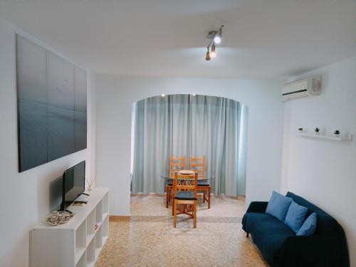 sala de estar con sofá azul y mesa en Bonito estudio, Torremolinos, COSTA DEL SOL, en Torremolinos