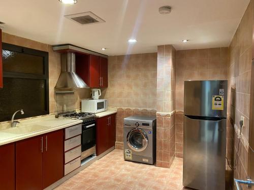 uma cozinha com um frigorífico de aço inoxidável e uma máquina de lavar louça em Garden City 2 em Riade