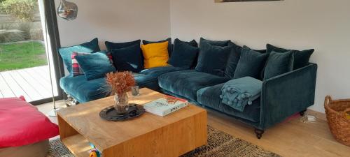 a living room with a blue couch and a coffee table at Maison Joli Soir à Ambleteuse in Ambleteuse