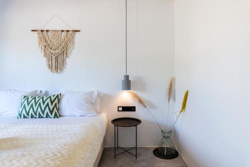 - une chambre avec un lit et une table dans l'établissement Yalos Mykonos 4 Bedroom Luxury house 5 minute from Ornos Beach w sea & Sunset view, à Mykonos