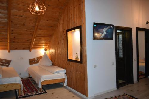 a bedroom with two beds and a tv on the wall at Clematis House in Voronet