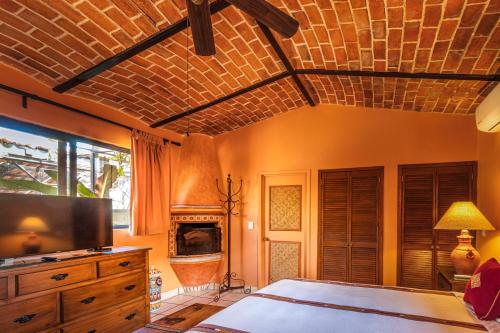a bedroom with a bed and a tv and a fireplace at Casa del Sol Inn in Ajijic