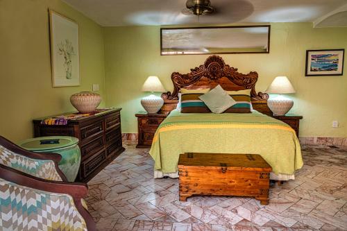 a bedroom with a large bed with a wooden headboard at Casa del Sol Inn in Ajijic