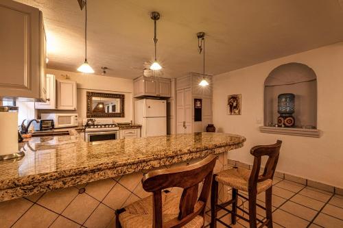 a kitchen with a counter and two chairs in a room at Casa del Sol Inn in Ajijic