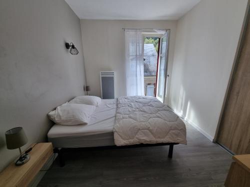 um quarto branco com uma cama e uma janela em Coeur de Cauterets appartement 53m² 4/6 personnes em Cauterets