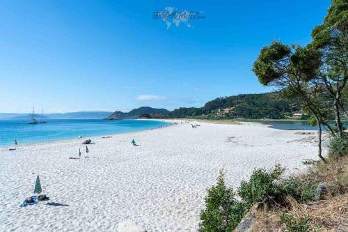 ein Strand mit vielen Menschen und dem Ozean in der Unterkunft Apartamento Redondela céntrico in Pontevedra