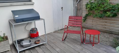 a red chair sitting next to a tv on a patio at Maison Joli Soir à Ambleteuse in Ambleteuse