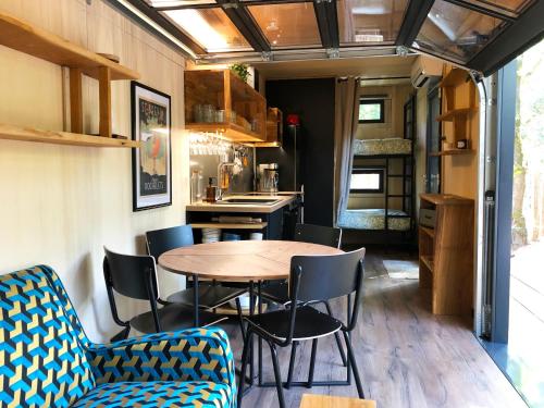 une salle à manger avec une table et des chaises dans une caravane dans l'établissement Vaimiti, cabane cosy sous les pins (50m de la plage), à Saint-Brévin-les-Pins