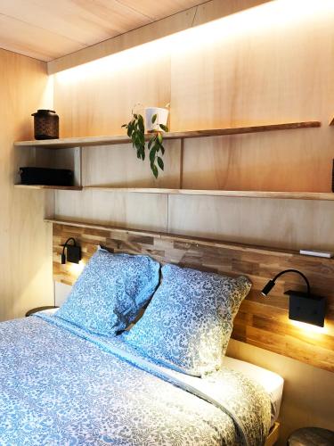 - une chambre avec un lit avec une étagère au-dessus dans l'établissement Vaimiti, cabane cosy sous les pins (50m de la plage), à Saint-Brévin-les-Pins