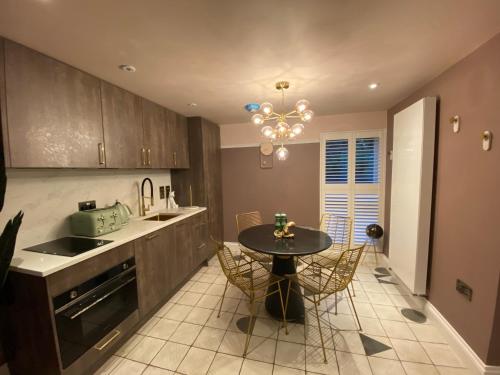 a kitchen with a table and chairs in a kitchen at Ailim House Serviced Cottage Escape, around the corner from the Old Course in St. Andrews