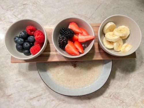three bowls of fruit on a wooden tray at Ailim House Serviced Cottage Escape, around the corner from the Old Course in St. Andrews