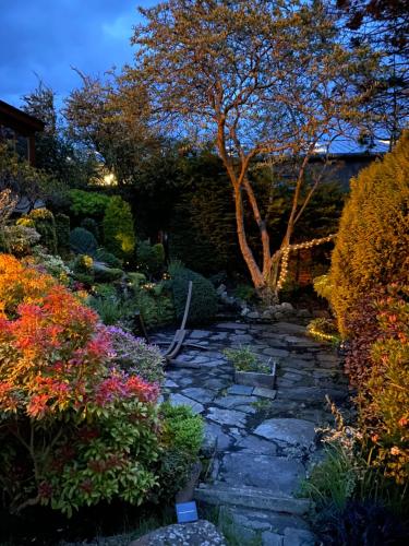 a stone path in a garden with flowers and a tree at Ailim House Serviced Cottage Escape, around the corner from the Old Course in St. Andrews