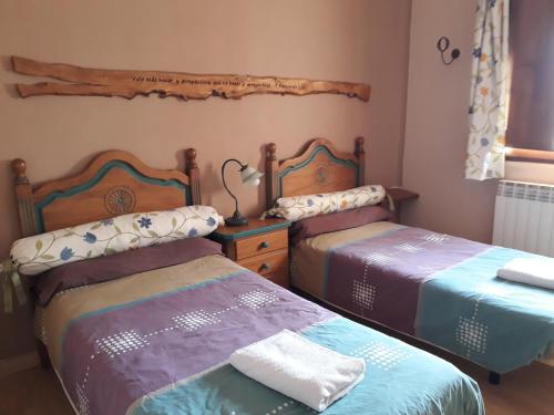 ein Schlafzimmer mit 2 Betten und einem Tisch mit einer Lampe in der Unterkunft Casa El Secretario in S’Arenal
