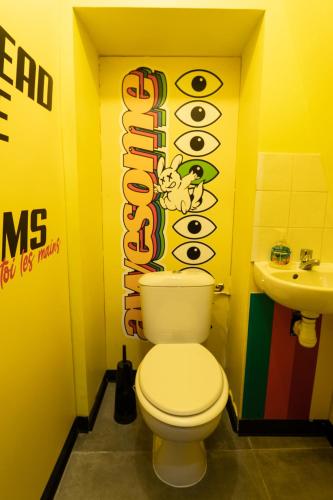 a bathroom with a toilet and a sign with an eye sign at Capsule Art Déco - Jacuzzi - Netflix - Home Cinéma - Arcade de jeux & Nintendo switch - 2 chambres - Filet suspendu in Valenciennes