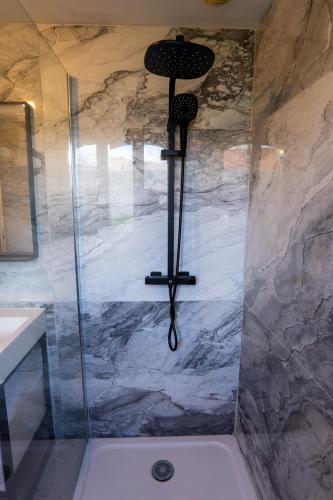 a shower with a shower head in a bathroom at Capsule Art Déco - Jacuzzi - Netflix - Home Cinéma - Arcade de jeux & Nintendo switch - 2 chambres - Filet suspendu in Valenciennes