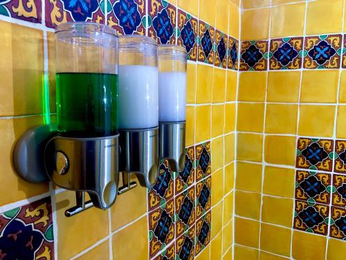 a tiled wall with four cups on a wall at Casa del Sol Inn in Ajijic