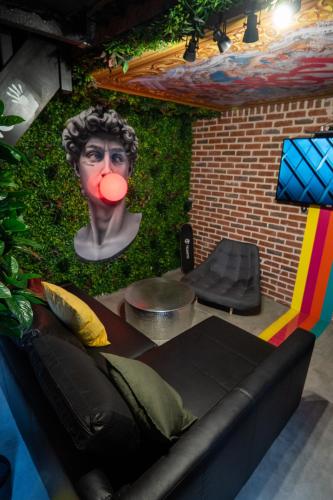 a room with a couch with a head on the wall at Capsule Art Déco - Jacuzzi - Netflix - Home Cinéma - Arcade de jeux & Nintendo switch - 2 chambres - Filet suspendu in Valenciennes