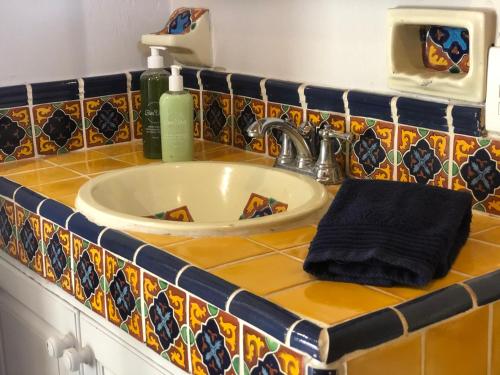 a bathroom sink with a black towel on a counter at Casa del Sol Inn in Ajijic