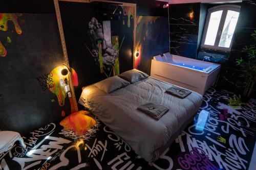 a bedroom with a bed with graffiti on the walls at Capsule Art Déco - Jacuzzi - Netflix - Home Cinéma - Arcade de jeux & Nintendo switch - 2 chambres - Filet suspendu in Valenciennes