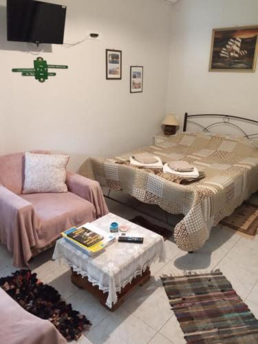 a living room with two beds and a couch at Roppas Studios Nostos in Kato Gatzea