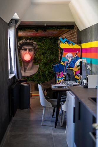 a room with a painting of a person with a red tongue at Capsule Art Déco - Jacuzzi - Netflix - Home Cinéma - Arcade de jeux & Nintendo switch - 2 chambres - Filet suspendu in Valenciennes