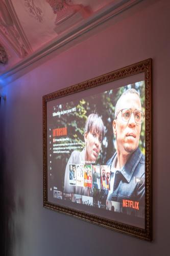 a picture of a movie in a frame on a wall at Capsule Art Déco - Jacuzzi - Netflix - Home Cinéma - Arcade de jeux & Nintendo switch - 2 chambres - Filet suspendu in Valenciennes