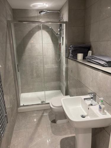 a bathroom with a shower and a toilet and a sink at Lovely 4 bed apartment in centre of Formby in Formby