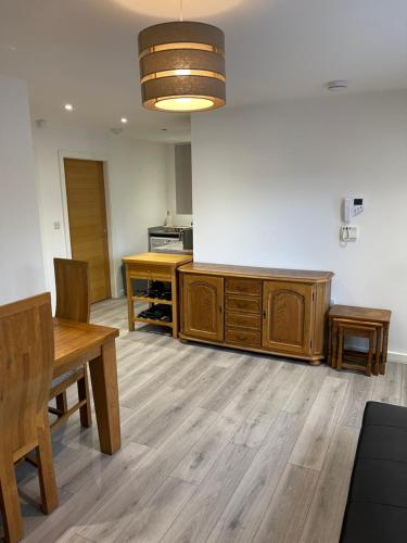a kitchen with a table and a wooden cabinet at Lovely, Sleeps 8, Parking, Cafe Bars Shops Beach Train, Central Formby in Formby