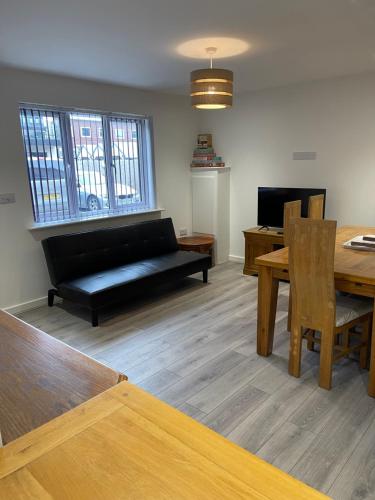 a living room with a couch and a table at Lovely, Sleeps 8, Parking, Cafe Bars Shops Beach Train, Central Formby in Formby