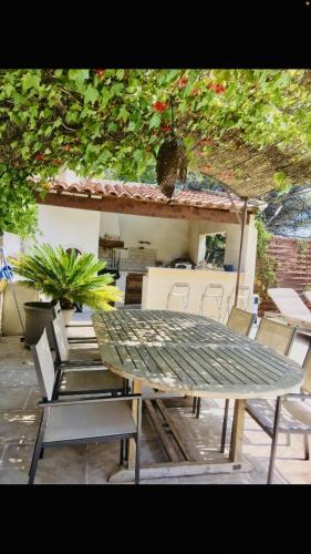 une table et des chaises vertes devant une maison dans l'établissement Villa piscine 6km de Cassis 12 couchages, à Roquefort-la-Bédoule