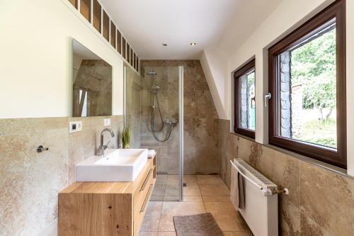 y baño con lavabo y ducha. en Landhaus Karbach komplett oder einzelne Wohneinheiten Villa inkl Sauna bzw Waldhäuschen, en Hirten